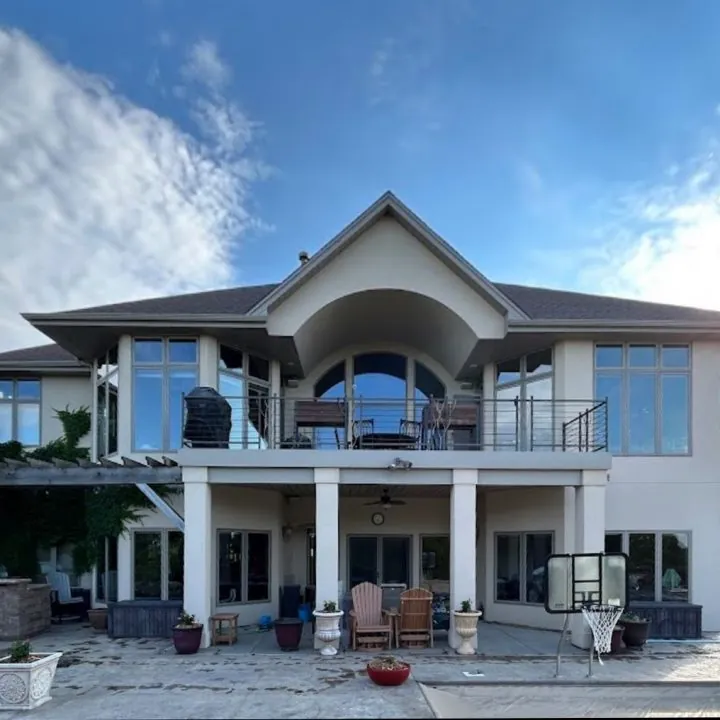 A two-story home with a balcony and tall clean windows