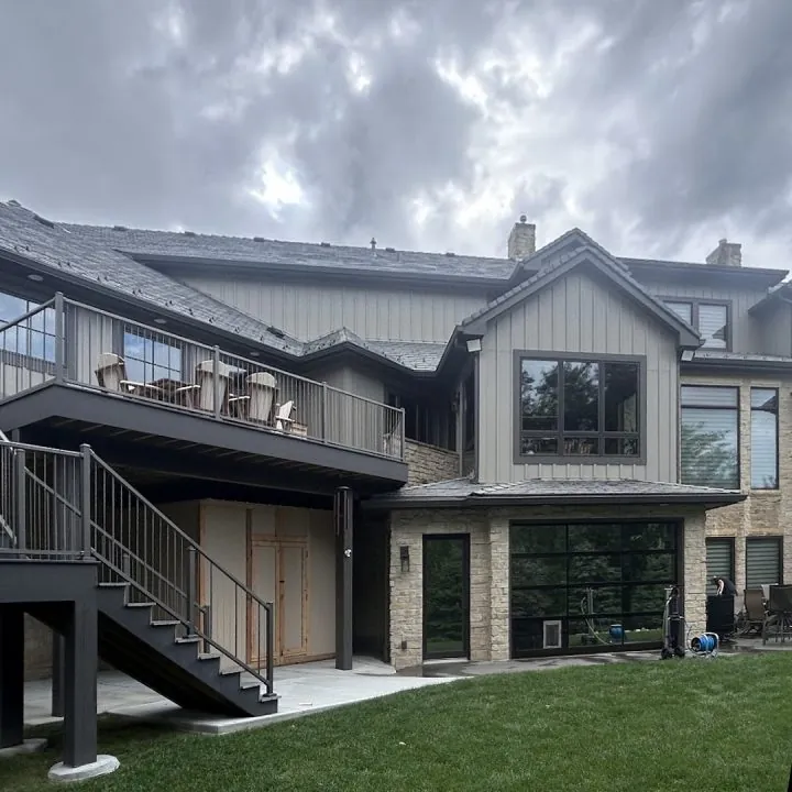 The back of a home with a deck and large clean windows
