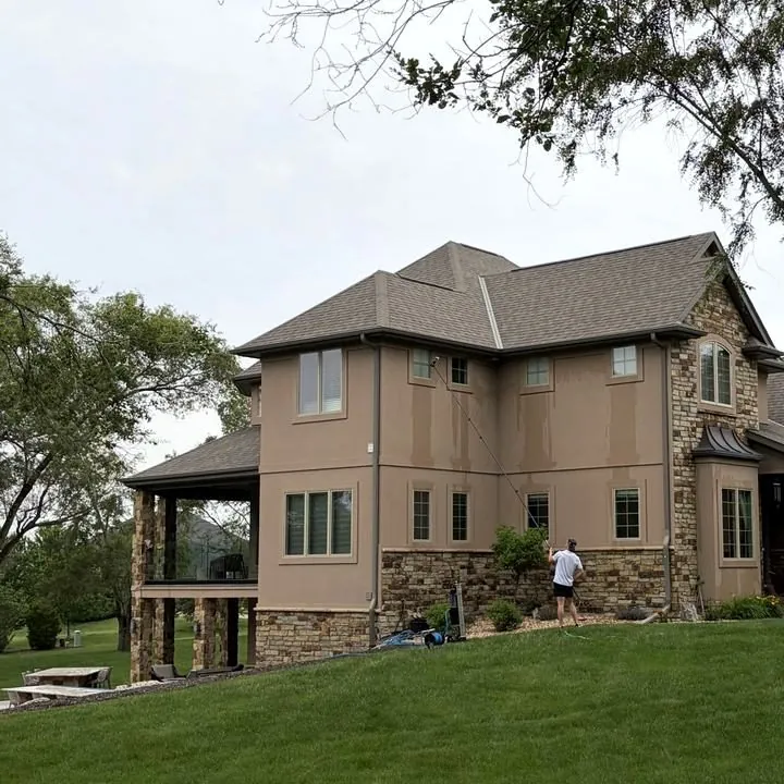 A stone and stucco home on a green lawn
