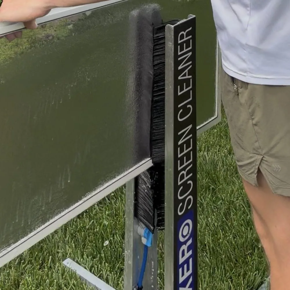 A window screen being run through a screen cleaner with bristle brushes and water jets